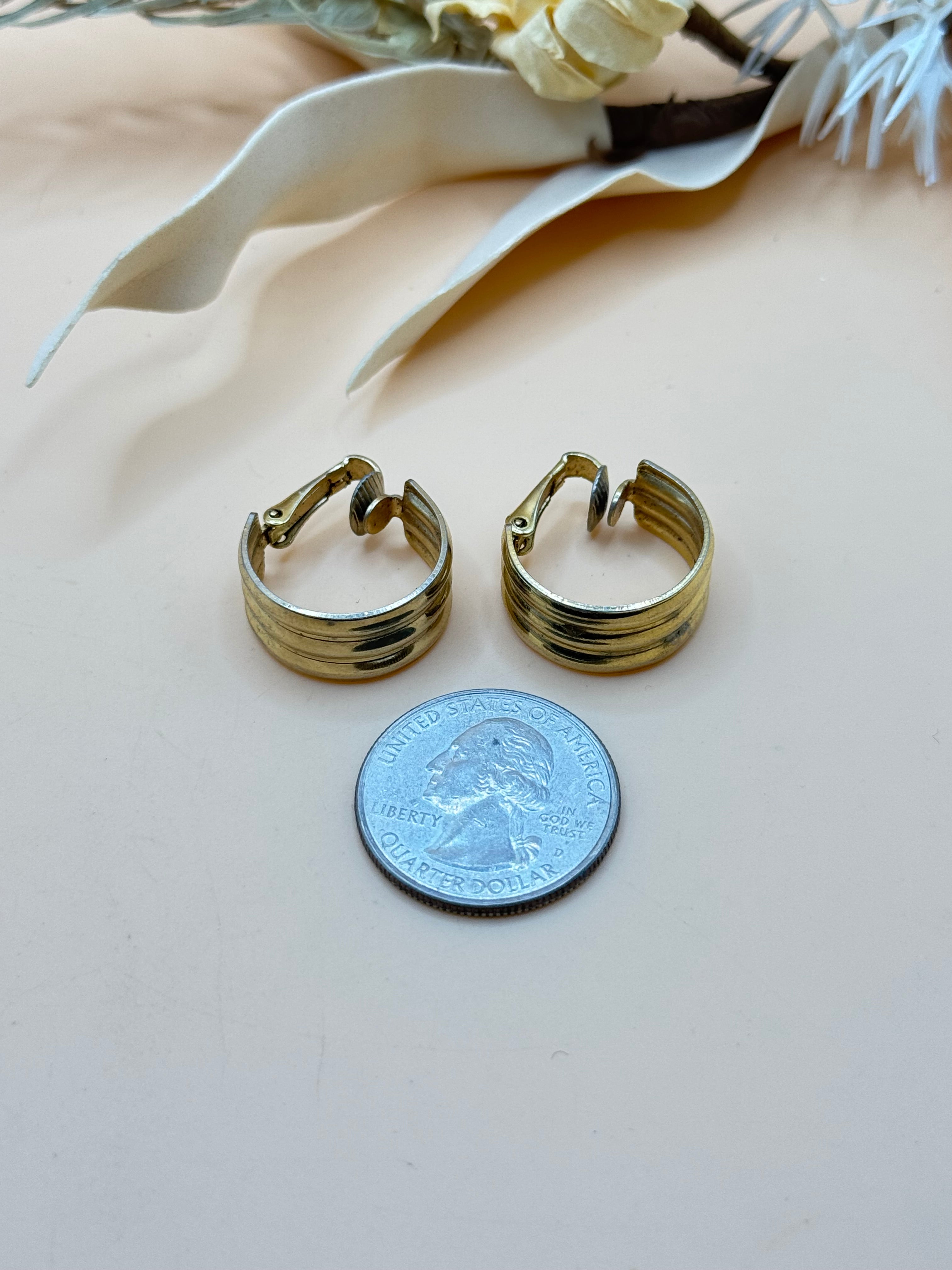 Classic vintage Monet gold tone hoop earrings with comfortable clip-on backs and a polished finish.
